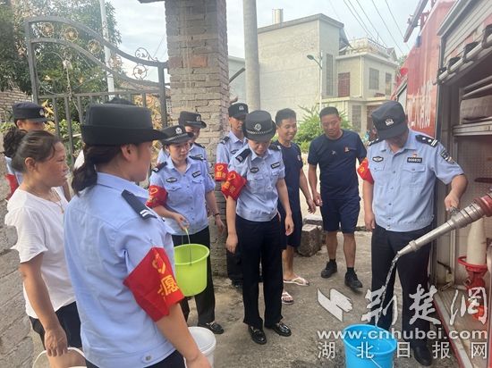 民輔警跟隨消防水車作業(yè)，通過肩挑手提的方式將清水送入行動(dòng)不便的老年、殘障村民的家中（通訊員 李麗君 攝） (3).jpg.jpg