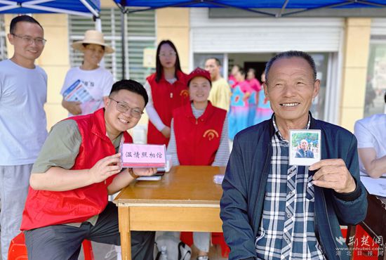 “溫情照相館”攤位上，前來照相的老人與志愿者開心地合影留念_副本.jpg