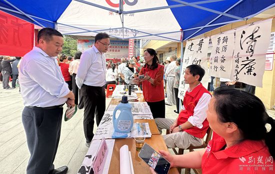 “文化惠民”攤位上，志愿者展示書法作品_副本.jpg